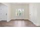 A bright and welcoming foyer with a glass front door, side windows, and stylish hardwood floors at 9165 Cherokee Dr, Hickory, NC 28601