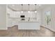 Modern kitchen features white cabinets, stainless steel appliances, and an island with a sink and pendant lighting at 9165 Cherokee Dr, Hickory, NC 28601