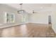 A spacious living room featuring hardwood floors, two large windows, modern lighting, and neutral walls at 9165 Cherokee Dr, Hickory, NC 28601