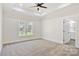 Spacious primary bedroom with a tray ceiling, neutral carpet, a ceiling fan, and natural light at 9165 Cherokee Dr, Hickory, NC 28601