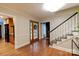 Welcoming foyer featuring wood floors, a staircase, and a charming entry door at 9439 White Hemlock Ln, Charlotte, NC 28270
