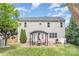 Backyard view of the two-story home with a patio, pergola, and well-maintained lawn at 9803 Forest Run Ln, Charlotte, NC 28277