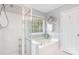 Bright bathroom featuring a shower and a soaking tub at 9803 Forest Run Ln, Charlotte, NC 28277