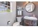 Charming powder room with a decorative mirror, vanity, and natural light from the window at 9803 Forest Run Ln, Charlotte, NC 28277