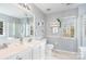 Bright bathroom featuring double sinks, vanity, and shower with glass doors at 9803 Forest Run Ln, Charlotte, NC 28277