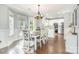 Bright dining area featuring a stylish chandelier, hardwood floors, and ample natural light at 9803 Forest Run Ln, Charlotte, NC 28277