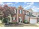 Charming two-story brick home featuring a two-car garage and professionally landscaped front yard at 9803 Forest Run Ln, Charlotte, NC 28277