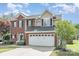 Charming two-story brick home featuring a two-car garage and professionally landscaped front yard at 9803 Forest Run Ln, Charlotte, NC 28277