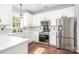 Well-lit kitchen featuring white cabinets, stainless steel appliances, and hardwood floors at 9803 Forest Run Ln, Charlotte, NC 28277