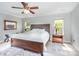 Bright main bedroom with a large bed, ceiling fan, two windows, and two night stands at 9803 Forest Run Ln, Charlotte, NC 28277