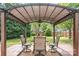 Outdoor patio featuring a pergola with a table and four chairs on a brick-paved area at 9803 Forest Run Ln, Charlotte, NC 28277