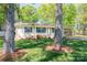 Lovely brick home with green shutters, a front porch, and a carport, nestled among mature trees at 1 Horace Grigg Cir, Shelby, NC 28152