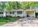 Inviting single-story brick home featuring a covered front porch and an attached carport on a sunny day at 1 Horace Grigg Cir, Shelby, NC 28152