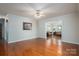 Bright living room with gleaming hardwood floors, ceiling fan, and view into sunroom at 1 Horace Grigg Cir, Shelby, NC 28152