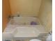 This image shows the bathtub with tile wall and cleaning supplies at 107 N Rudisill Ave, Cherryville, NC 28021