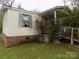 Shows the exterior of a single story home with a covered porch and overgrown landscaping at 107 N Rudisill Ave, Cherryville, NC 28021