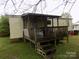 View of the home's covered porch and siding with green lawn area at 107 N Rudisill Ave, Cherryville, NC 28021