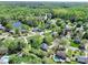 An aerial view of homes in a lush, green neighborhood featuring mature trees and some with backyard pools at 111 Woodfern Pl, Mooresville, NC 28115