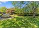 Grassy backyard with a patio and mature landscaping, creating a serene and private outdoor space at 111 Woodfern Pl, Mooresville, NC 28115