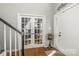 Bright foyer with hardwood floors, white trim, glass panel doors, and stairs at 111 Woodfern Pl, Mooresville, NC 28115