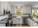 Bright kitchen featuring white cabinetry, countertops, and stainless steel appliances at 111 Woodfern Pl, Mooresville, NC 28115