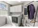 Bright laundry room with modern washer and dryer, convenient hanging rack and storage cabinets at 111 Woodfern Pl, Mooresville, NC 28115