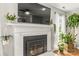 Cozy living room features a fireplace with a large television and beautiful decorative plants at 111 Woodfern Pl, Mooresville, NC 28115