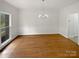Empty dining room showcasing hardwood floors, white walls, chair rail, and an elegant chandelier at 1121 Setter Se Ln, Concord, NC 28025