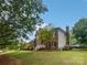 Side view of home, showcasing brick, siding, mature trees, and a manicured lawn at 1121 Setter Se Ln, Concord, NC 28025