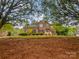 Lovely red brick home from ground level, showcasing mature trees and front yard at 1121 Setter Se Ln, Concord, NC 28025