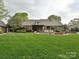 Large grassy backyard features in-ground pool and hot tub, covered patio area, mature trees at 1126 Concord Rd, Davidson, NC 28036