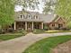Elegant brick home featuring a welcoming front porch, well-maintained lawn, and inviting curb appeal at 1126 Concord Rd, Davidson, NC 28036