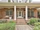 Inviting front porch with ample seating, brick columns, and decorative details for relaxing outdoors at 1126 Concord Rd, Davidson, NC 28036