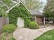 Charming garage with an entrance covered in ivy and sitting area with pergola provides curb appeal at 1126 Concord Rd, Davidson, NC 28036