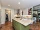 Kitchen with stainless steel appliances, brick backsplash, hardwood floors, and island with sink at 1126 Concord Rd, Davidson, NC 28036