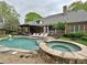 Backyard featuring in-ground pool, hot tub with stone surround, deck chairs and covered patio at 1126 Concord Rd, Davidson, NC 28036