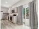 Bright kitchen featuring stainless steel appliances, stone countertops, and access to outdoor deck at 113 Mcgill Nw Ave, Concord, NC 28025
