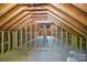 An unfinished attic with exposed wooden beams and trusses ready for renovation at 113 S College St, Monroe, NC 28112