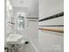 Bathroom with white and black tile, sink, toilet, and combination shower/tub at 113 S College St, Monroe, NC 28112