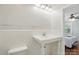 Cozy bathroom featuring a white sink, toilet, tile and an open doorway to the bedroom at 113 S College St, Monroe, NC 28112