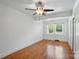 Bright, empty bedroom featuring hardwood floors, neutral walls, and a ceiling fan at 113 S College St, Monroe, NC 28112