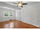 Well-lit bedroom with hardwood floors, white trim, and a ceiling fan at 113 S College St, Monroe, NC 28112
