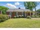Charming brick home with a well-maintained front lawn and covered porch, exuding curb appeal at 113 S College St, Monroe, NC 28112
