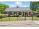 Charming brick home with a well-maintained front lawn and gated front yard at 113 S College St, Monroe, NC 28112