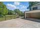 An attached garage featuring a spacious concrete parking pad, an open door and a fenced yard at 113 S College St, Monroe, NC 28112