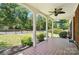 Relaxing covered porch featuring white pillars, brick tile flooring, and a ceiling fan at 113 S College St, Monroe, NC 28112