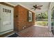 Cozy covered porch with brick details, a ceiling fan, and a welcoming front door at 113 S College St, Monroe, NC 28112
