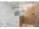 Bright bathroom featuring a glass shower, soaking tub, and window at 1176 Shiloh Bend Trl, Fort Mill, SC 29715