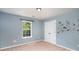 Bedroom with light blue walls, beige carpet, window, closet and construction-themed wall decor at 1176 Shiloh Bend Trl, Fort Mill, SC 29715