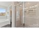 Modern bathroom featuring a glass shower with tiled walls and a soaking tub with a large window offering natural light at 1198 Links Crossing Dr # 162P, Monroe, NC 28112